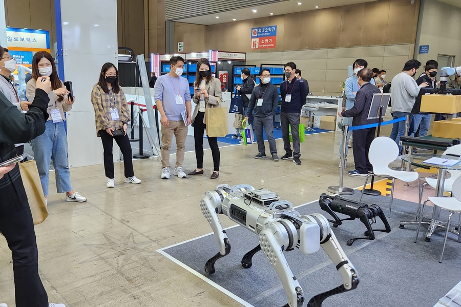 2022 로보월드 전시장을 방문한 관람객들이 사족보행로봇을 흥미진진하게 보고 있다.